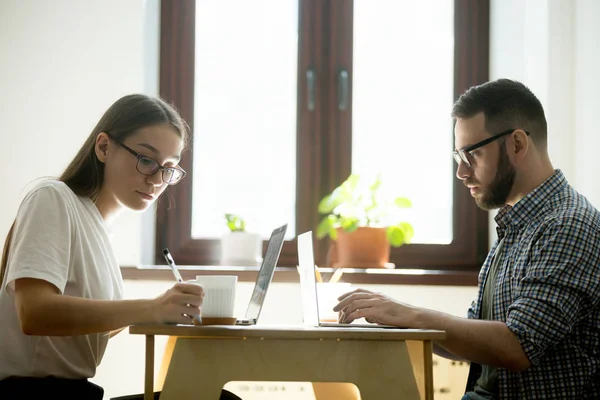 Adam ve bir kafede dizüstü bilgisayarlarda çalışan kadın notlar. — Stok fotoğraf