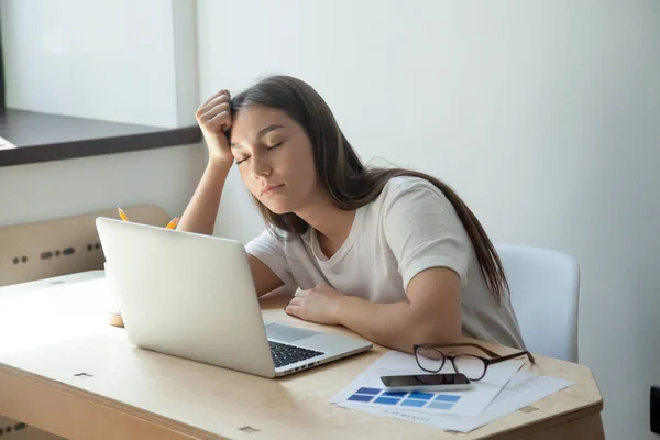 Joven diseñadora femenina adulta durmiendo en su escritorio . — Foto de Stock