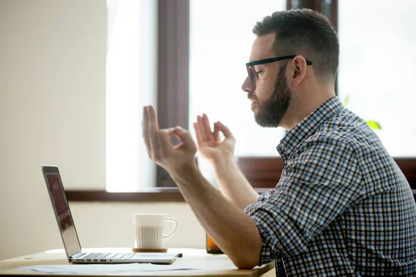 Jonge volwassen werknemer mediteren in zijn stoel van het Bureau. — Stockfoto