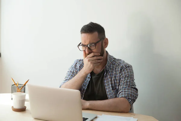 Giovane uomo adulto lettura terribile articolo di notizie nel suo computer portatile calcolare — Foto Stock