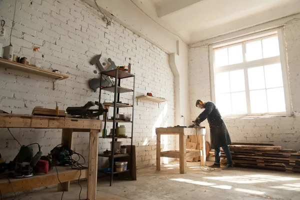 Großzügiger Werkstattinnenraum mit Heimwerker, der mit Elektrowerkzeug arbeitet — Stockfoto