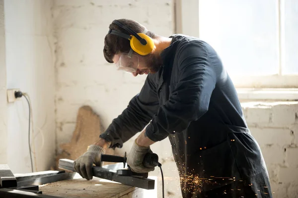 Worker in protective clothes working in workshop