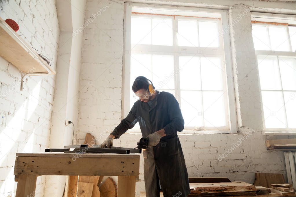 Carpenter works in custom furniture manufacturing