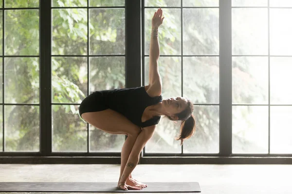 Genç çekici kadın sandalyede dönüyordu poz, stüdyo arka plan