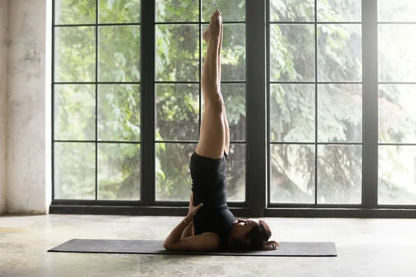 Mujer atractiva joven en la pose de Salamba Sarvangasana, estudio espalda — Foto de Stock