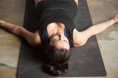 Ceset genç çekici kadın poz, stüdyo kat arka plan