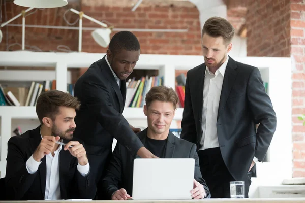 Equipe multiétnica de funcionários corporativos olhando para a tela do laptop — Fotografia de Stock