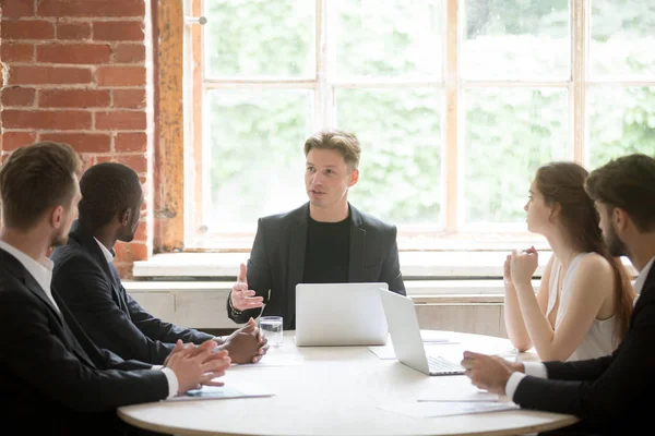 Jeune patron donnant des instructions à un groupe d'employés lors d'une réunion d'information — Photo