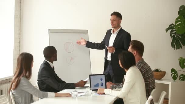 Empresario blanco confiado dando la presentación a diversos colegas en oficina — Vídeo de stock