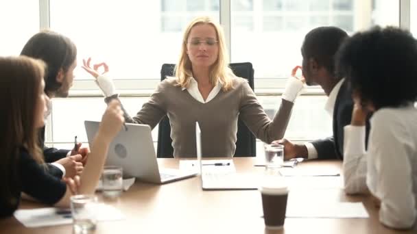 Mujer de negocios tranquila meditando en la reunión con colegas multirraciales, sin estrés — Vídeos de Stock