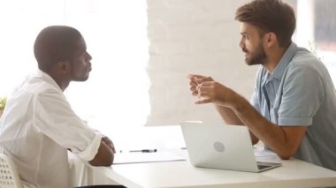 Ofiste müzakere konuşan iki farklı Afrika ve Kafkas işadamları