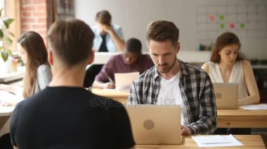 Çok etnik gruptan oluşan iş adamları ile yer coworking içinde dizüstü bilgisayar üzerinde çalışan iş adamı