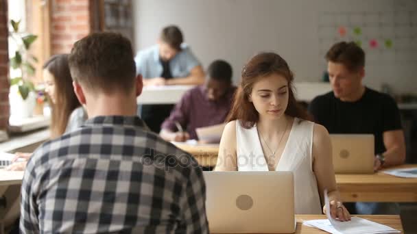 Jovem mulher trabalhando no espaço de coworking conversando com colega afro-americano — Vídeo de Stock