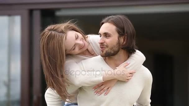 Loving husband holding wife on back enjoying leisure time outside — Stock Video