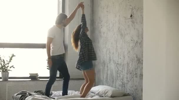 Pareja bailando en la cama, mujer girando alrededor sosteniendo la mano de los socios — Vídeos de Stock