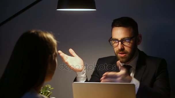 Successful businessman explaining problem to woman at late office meeting — Stock Video