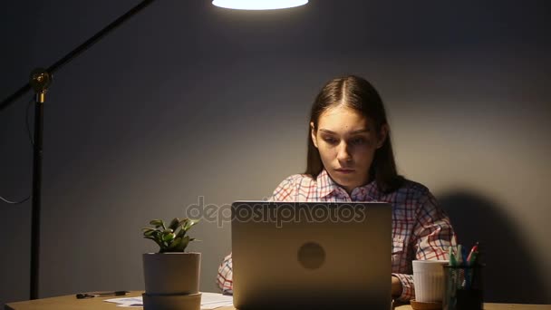 Giovane donna focalizzata utilizzando computer portatile che lavora fino a tardi gli straordinari su pc — Video Stock