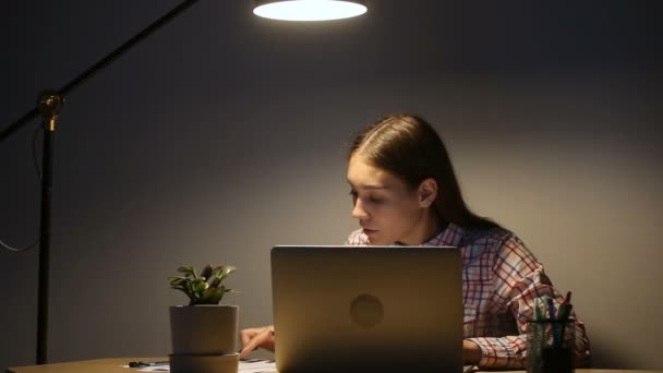 Mujer joven que trabaja hasta tarde en la oficina en el ordenador portátil, beber café — Vídeos de Stock
