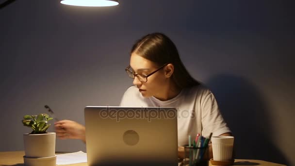 Giovane studente serio che studia usando il computer portatile, donna che lavora fino a tardi — Video Stock