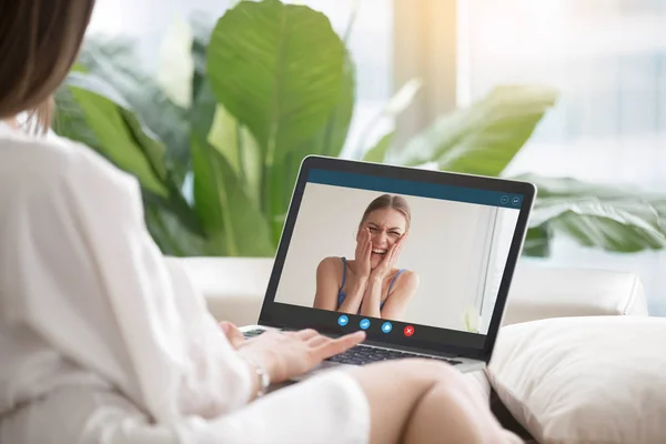 Casual woman talking to laughing girlfriend via video conference — Stock Photo, Image