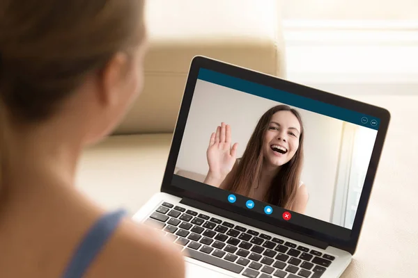 Happy young girl waving to girlfriend from laptop screen. — Stock Photo, Image