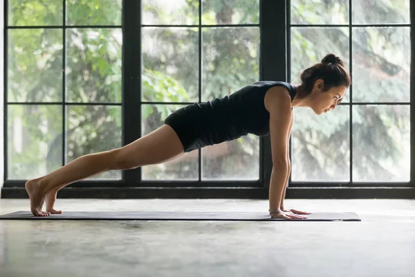 Young attractive woman in Plank pose, studio background — Stock Photo, Image