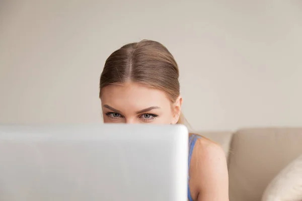 Curious teen using computer, young funny girl peeking over lapto — Stock Photo, Image