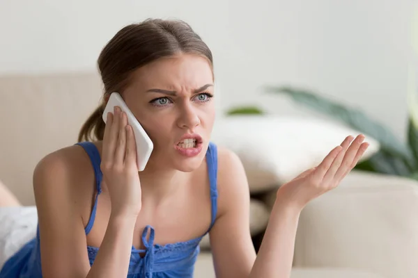 Mujer joven enojada discutiendo hablando por teléfono celular en casa — Foto de Stock