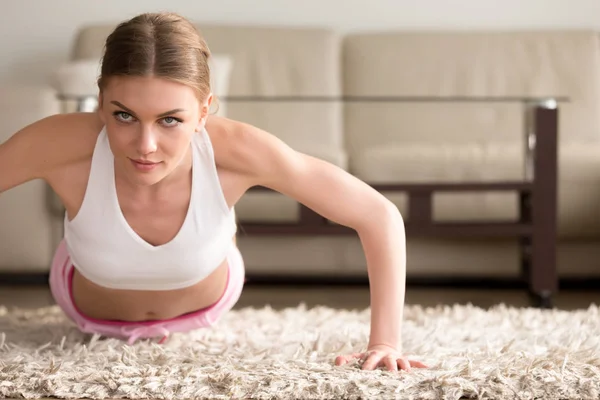 Jovem mulher esportiva fazendo flexões, exercício de prancha em casa — Fotografia de Stock