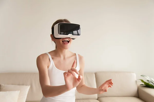 Eccitato giovane donna che indossa VR auricolare toccare la realtà virtuale — Foto Stock