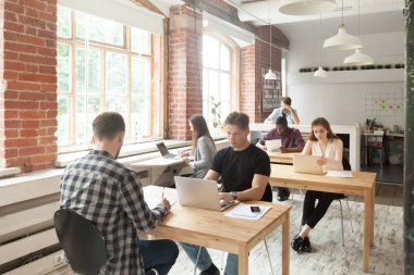 Genç raslantı kapalı paylaşılan coworking içinde iş yerinde çalışanların giyinmiş