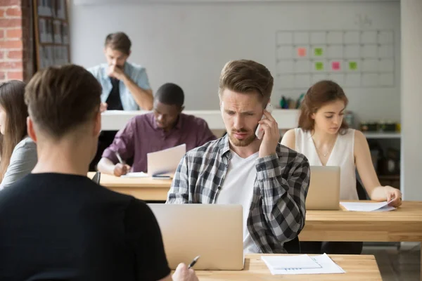 Entrepreneur occasionnel perplexe faire un appel téléphonique sur le lieu de travail . — Photo