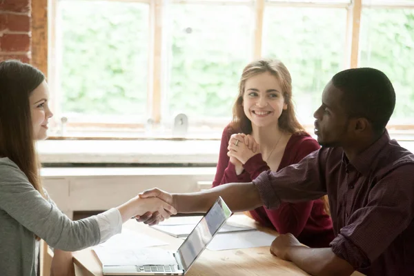 Jonge multi-etnisch paar handen schudden met makelaar. — Stockfoto