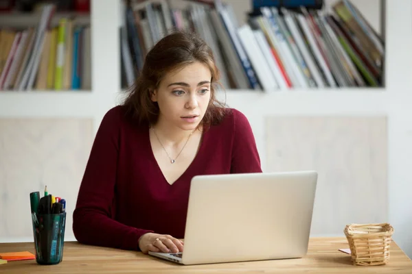 Młoda kobieta interesu dorywczo wpatrując się w ekran laptopa z to — Zdjęcie stockowe