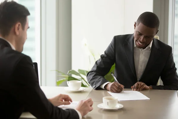 Black entrepreneur singing contract at office — Stock Photo, Image
