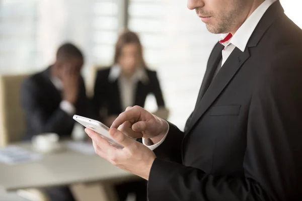 Empresario usando celular en reunión en la oficina — Foto de Stock