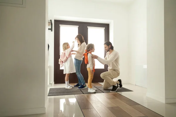 Föräldrar får barn redo för skolan promenad står vid hallen — Stockfoto