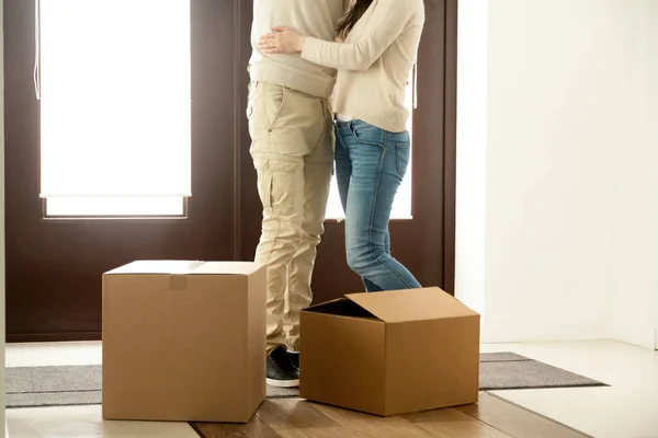 Пара обнимающихся стоящих возле картонных коробок, переезжающих в новые — стоковое фото