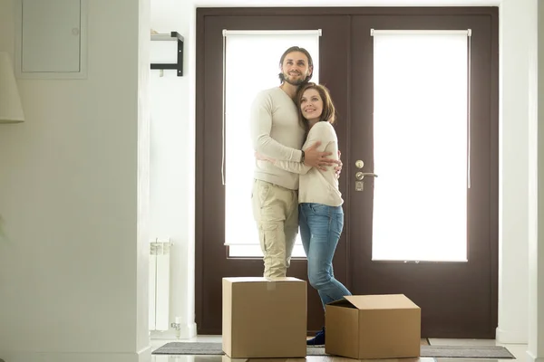 Moving day concept, excited couple homeowners embracing in new h