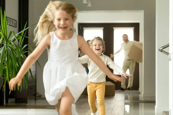 Crianças excitadas correndo na câmera, família se movendo na nova casa — Fotografia de Stock