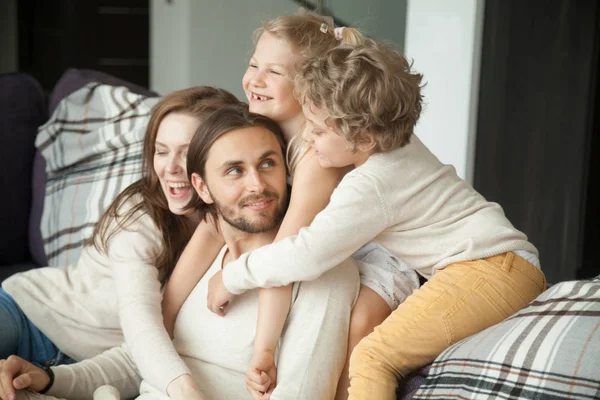 Bambini e moglie abbracciare il marito papà sul divano, giorno dei padri — Foto Stock