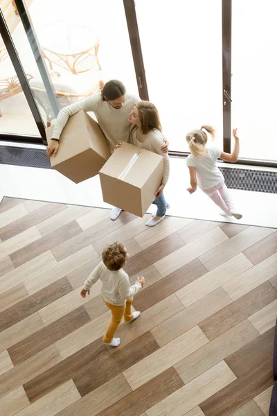 Семья с коробками переезжает в новый дом, вид сверху по вертикали — стоковое фото
