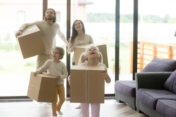 Bambini di famiglia eccitati che entrano in nuova casa il giorno del trasloco — Foto Stock