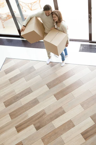 Feliz joven pareja entrando en casa sosteniendo cajas, moviéndose en — Foto de Stock