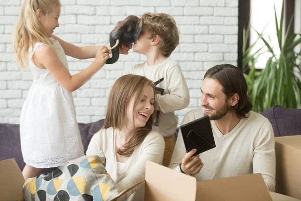 Feliz familia alegre desempacar cajas de embalaje juntos, moviendo i — Foto de Stock