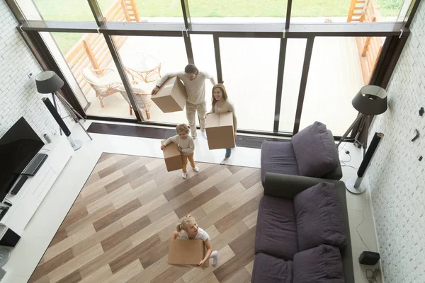 Niños de la familia llevando cajas moviéndose en casa nueva, vista superior — Foto de Stock