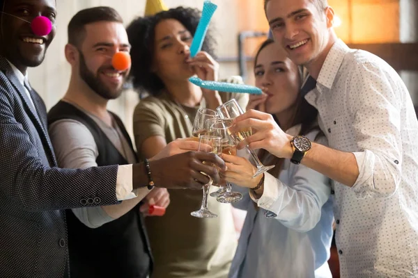 Mnohonárodnostní mladých lidí cinkání sklenic foukat píšťalky celebrita — Stock fotografie