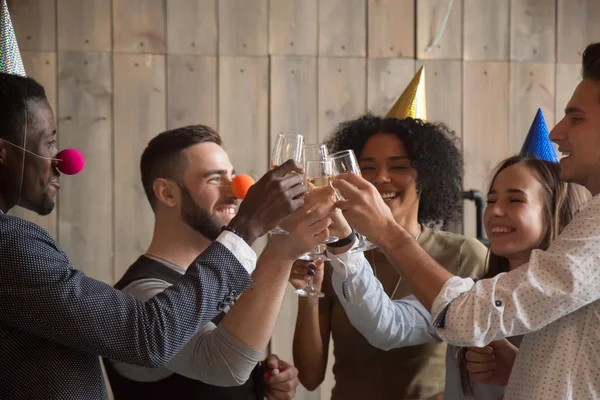 Afrikanische und kaukasische junge Freunde, die Gläser klirren lassen und feiern — Stockfoto