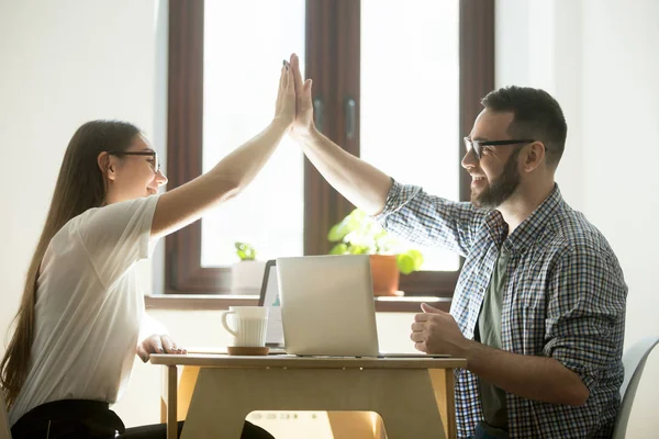 Zakelijk succes: twee gelukkige werknemers maken hoge vijf in kantoor — Stockfoto