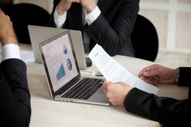 Dizüstü bilgisayar ekranında Proje istatistikleri ile anlaşma satın alma başlatma dikkate alınarak belge holding işadamı eller üç ortakları yatırımcılar, Ofis Toplantı de sözleşme altında müzakerelerin yakın görünümü